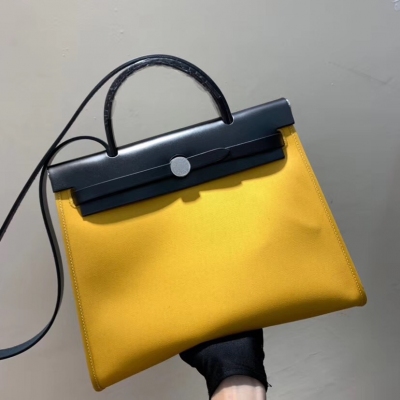 愛馬仕Hermes Herbag 31cm有兩種，一種是雙肩背包（叫Herbag A Do，已經停產），一種是單肩背包（常年處於被搶購的狀態）。一般是牛皮+帆布的材質，顏色都比較的亮麗，有手柄有肩帶，非常實用。31cm