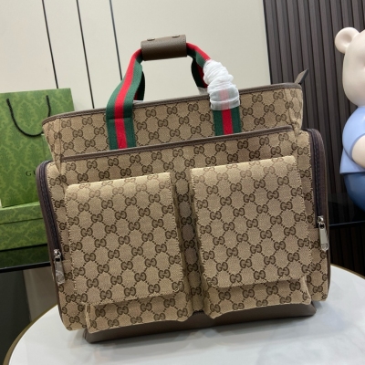 GUCCI古馳 新品 經典GG母嬰包。這款母嬰包採用米色和烏木色經典GG帆布精製而成，品牌標誌圖案與經典織帶交相輝映，盡顯標識內涵和典藏精髓。設有一個內部拉鍊口袋和五個外部口袋。這款母嬰包與配套嬰兒車適配，可通過兩條背包帶固定在嬰兒車上。米